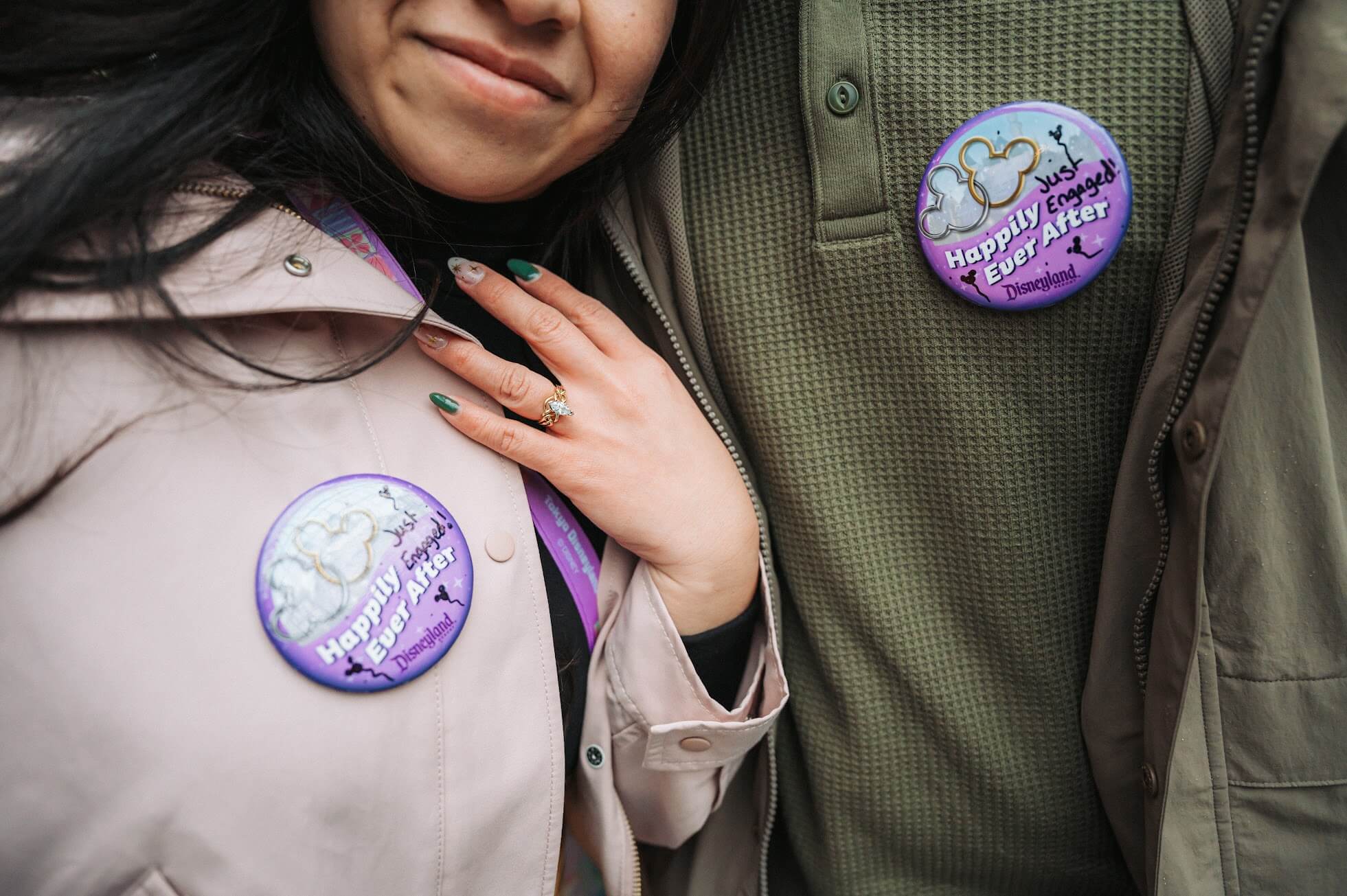 Brandon and Stephanie showing off their Happily Ever After Disneyland Pins from their photoshoot in Tokyo Disney.