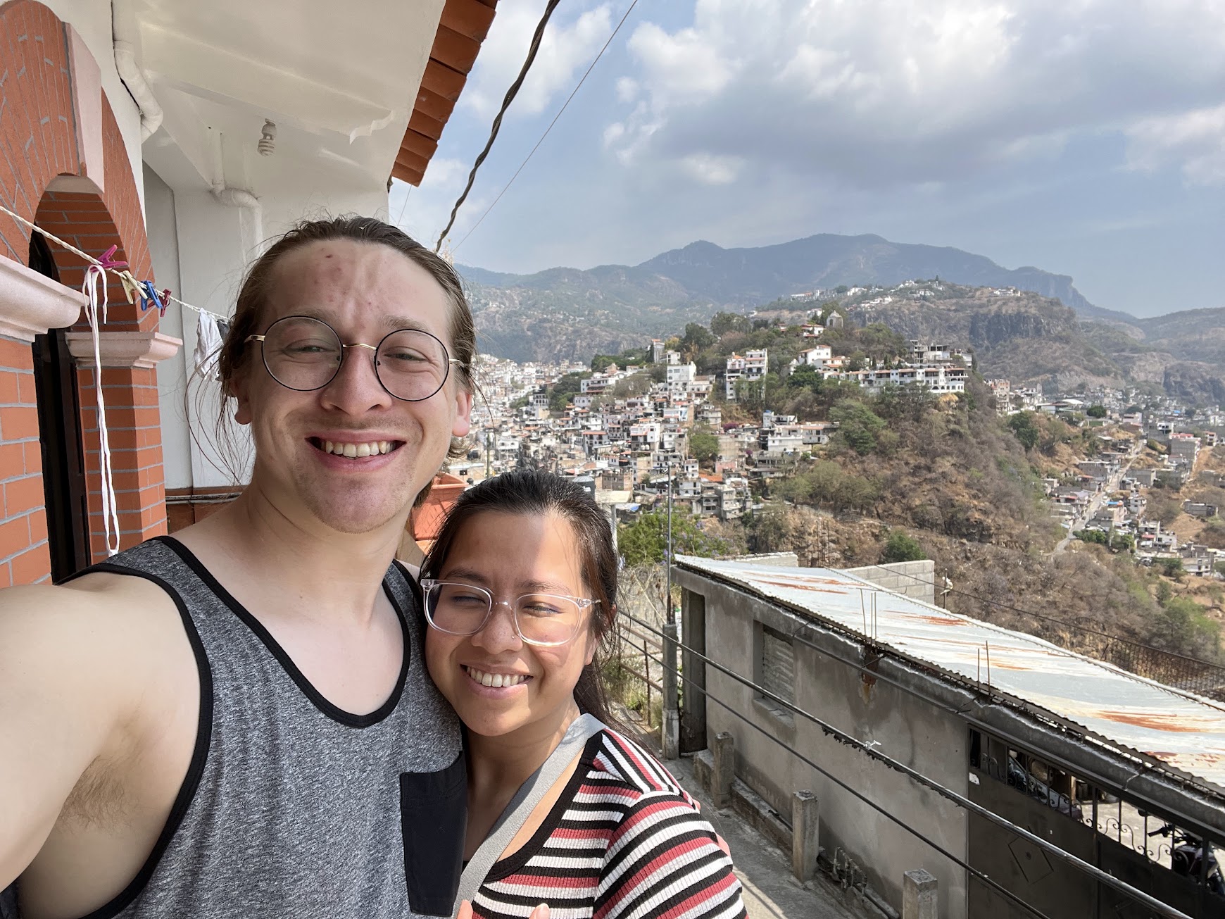 Stephanie and Brandon posing with the city of Taxco in the background
